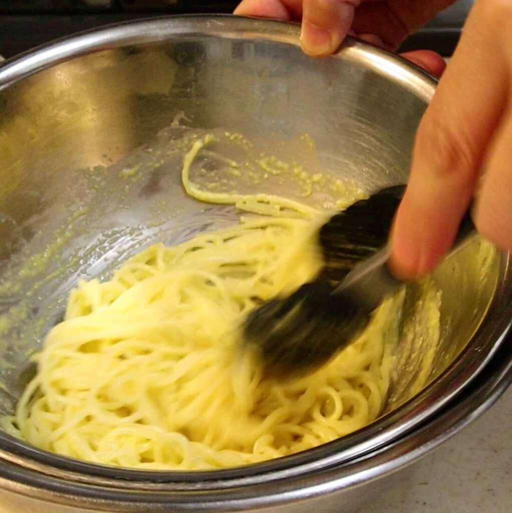 とうもろこしのピュレを少量加えながらパスタを混ぜているところ